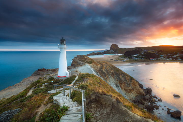 View along the Castlepoint coast during sunset, with a white Lighthouse on the cliffs