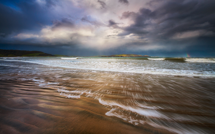 A stormy sky over a wide beach