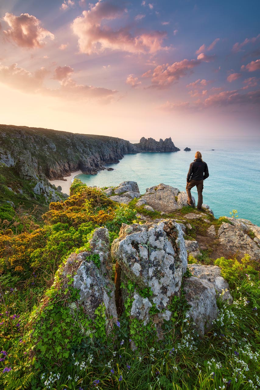 Beautiful sunrise near Porthcurno in Cornwall with spring flowers blooming on the cliffs.