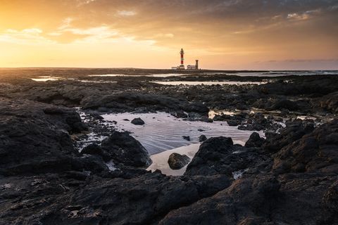 Faro de Toston The natural pools at Faro de Toston under a blazing Sunset.