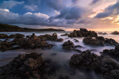 Fanad Dawn 2 Waves crash on the rocks at the end of a small beach beneath Fanad Lighthouse before sunrise.