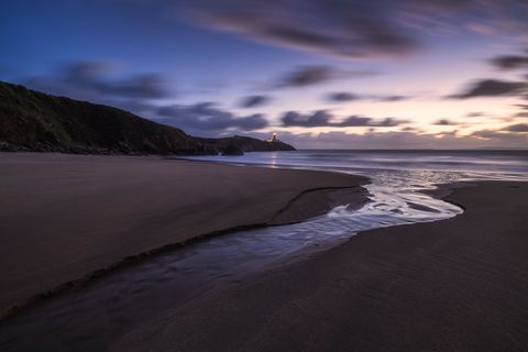 Fanad Dawn Dawn at Arryheerna Beach with Fanad Lighthouse at the horizon.