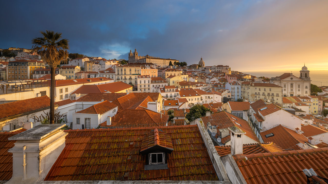 Farbiger Sonnenaufgang über dem Alfama Stadtteil in Lissabon