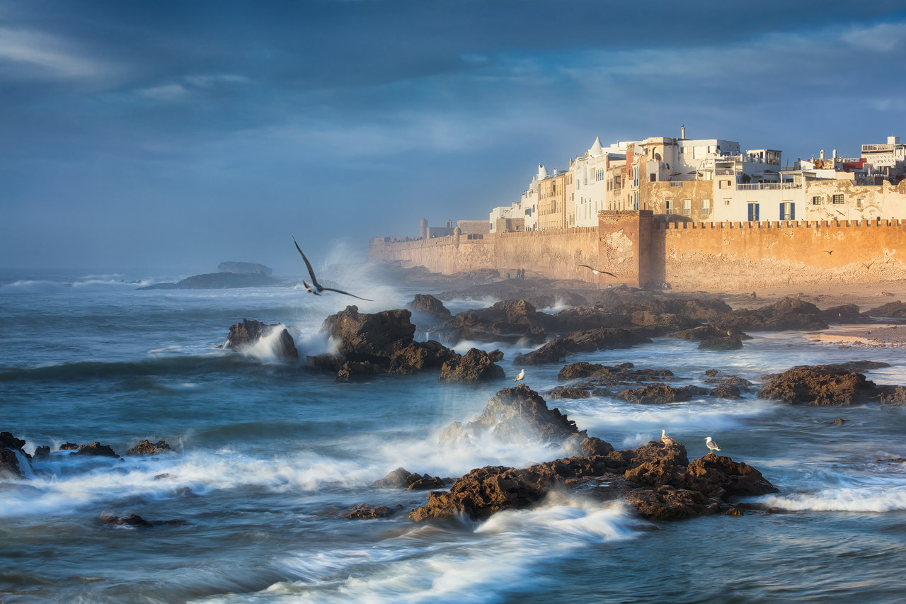 Wellen schlagen an die Küste vor der Stadtmauer von Essaouira.