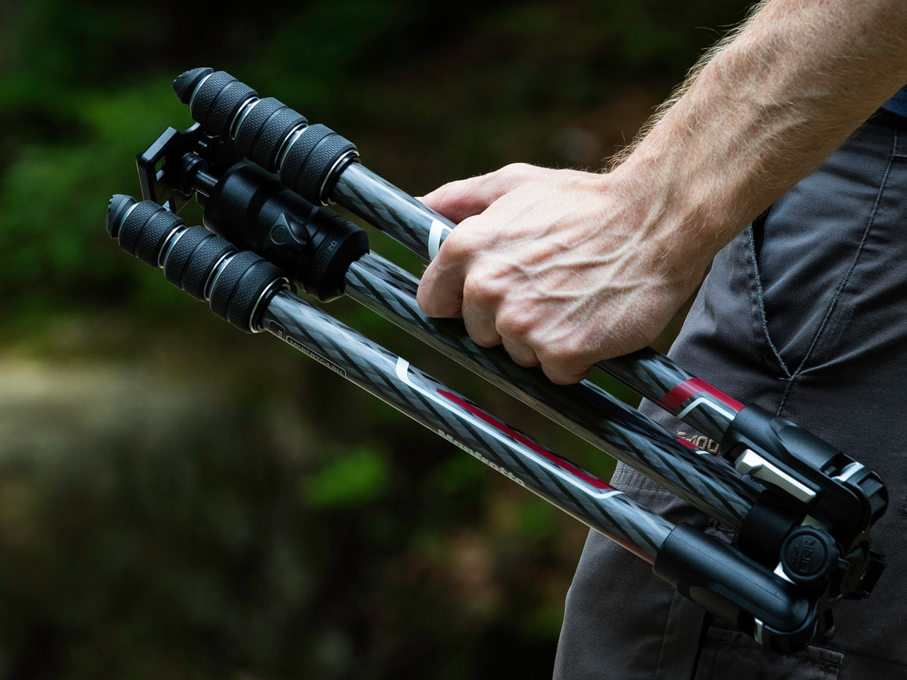 Photographer holding folded Manfrotto Tripod